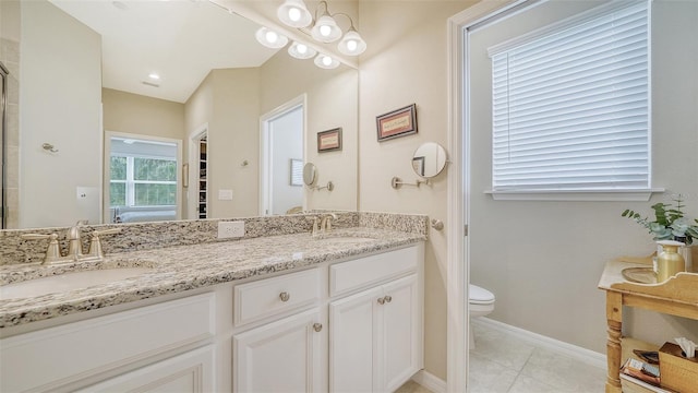 bathroom featuring tile flooring, toilet, and dual bowl vanity