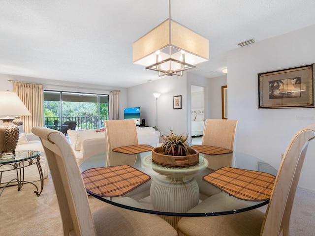 carpeted dining space with a textured ceiling