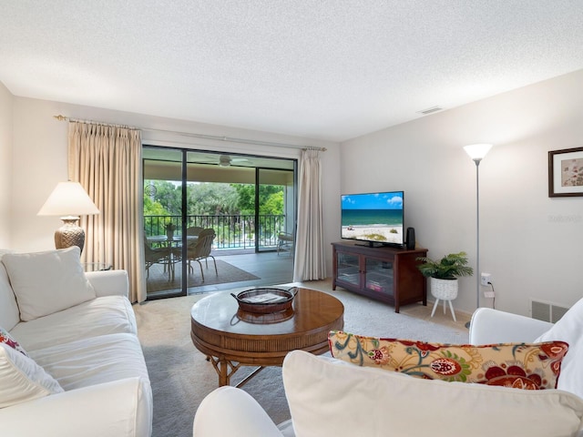 carpeted living room featuring a textured ceiling