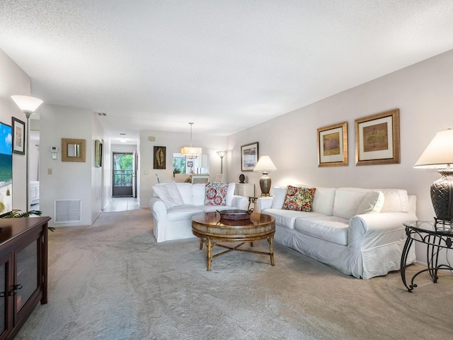 living room featuring light colored carpet and a textured ceiling