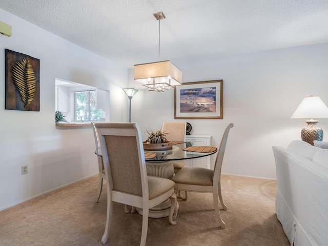 carpeted dining area with a notable chandelier and a textured ceiling