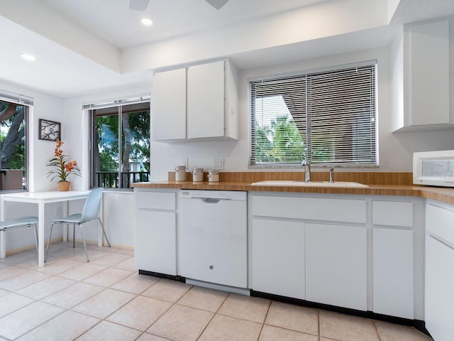 kitchen with white cabinets, white appliances, light tile floors, and plenty of natural light