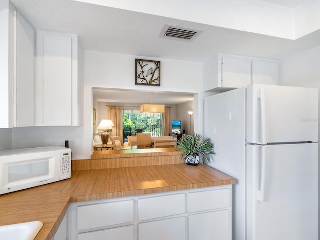 kitchen featuring white cabinets and white appliances