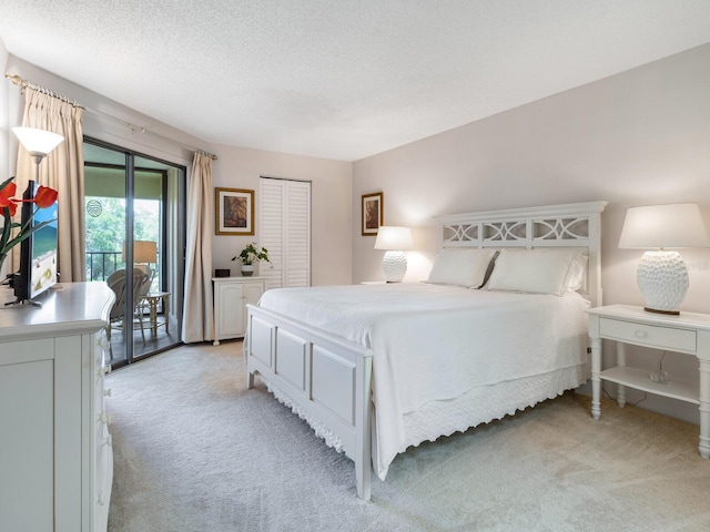 carpeted bedroom with a closet, access to exterior, and a textured ceiling