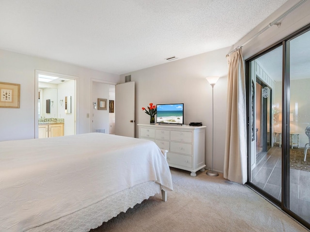 bedroom featuring light colored carpet, access to outside, a textured ceiling, and ensuite bathroom