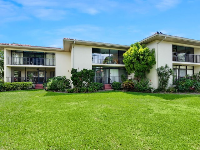 view of front of property with a front yard and a balcony