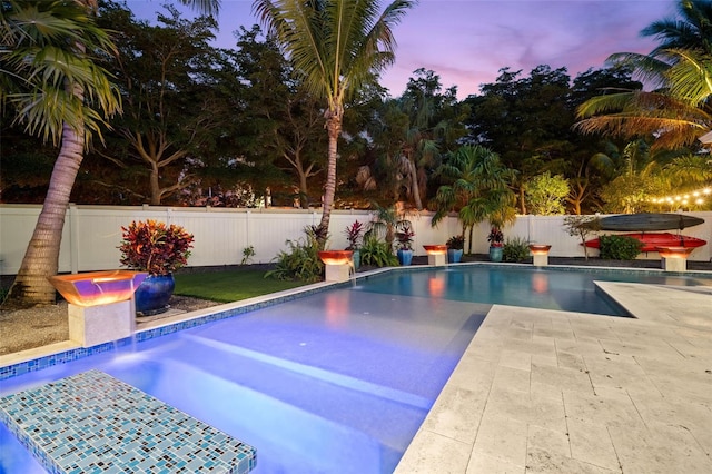 pool at dusk with a patio