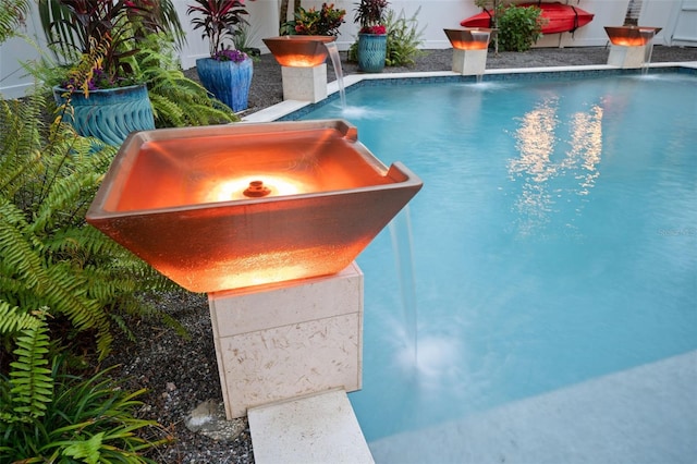 view of pool with pool water feature and an outdoor fire pit