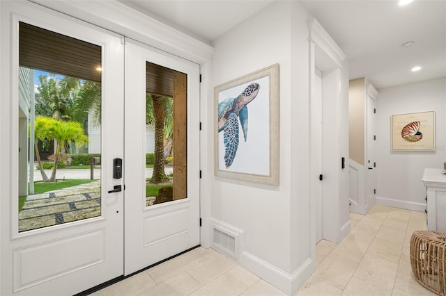 doorway with light tile patterned flooring and a healthy amount of sunlight