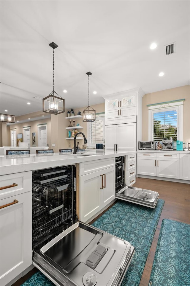 kitchen featuring pendant lighting, sink, white cabinetry, and dark hardwood / wood-style flooring