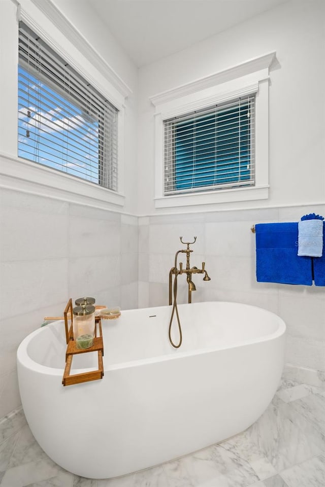 bathroom featuring tile walls and a tub