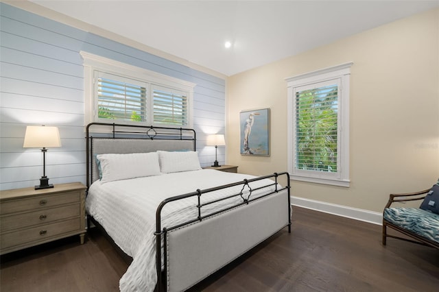 bedroom with dark hardwood / wood-style flooring and multiple windows