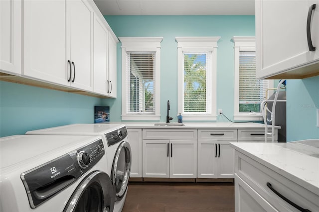 laundry room featuring cabinets, dark hardwood / wood-style flooring, sink, and washer and dryer