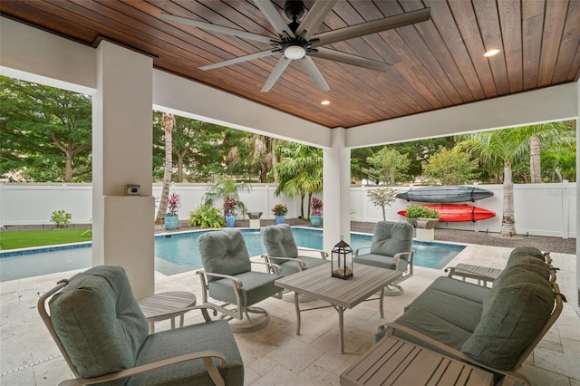 view of patio with ceiling fan and a pool with hot tub