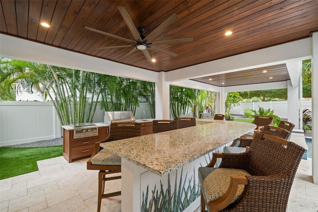 view of patio / terrace with a bar, grilling area, area for grilling, and ceiling fan