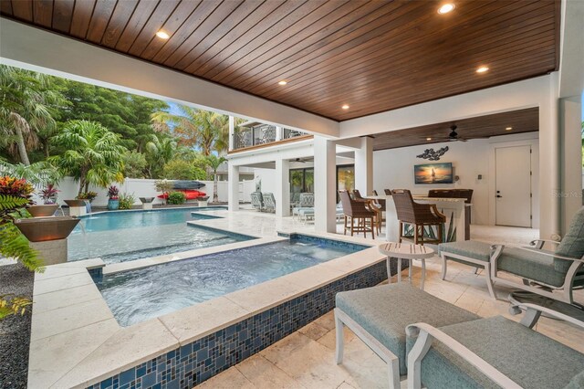 view of pool featuring an outdoor bar, ceiling fan, a patio, pool water feature, and an in ground hot tub