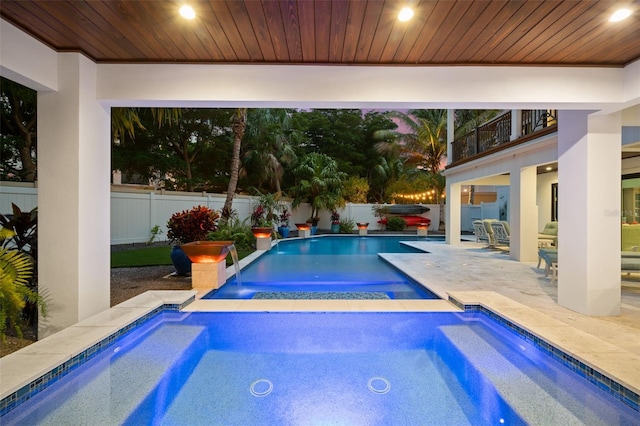 view of pool featuring an in ground hot tub, pool water feature, and a patio area