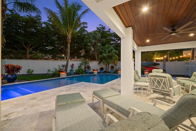 pool at dusk with a jacuzzi, a patio, and ceiling fan