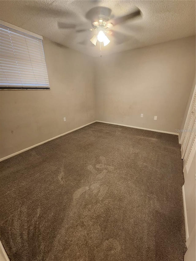 unfurnished room with carpet floors, ceiling fan, and a textured ceiling