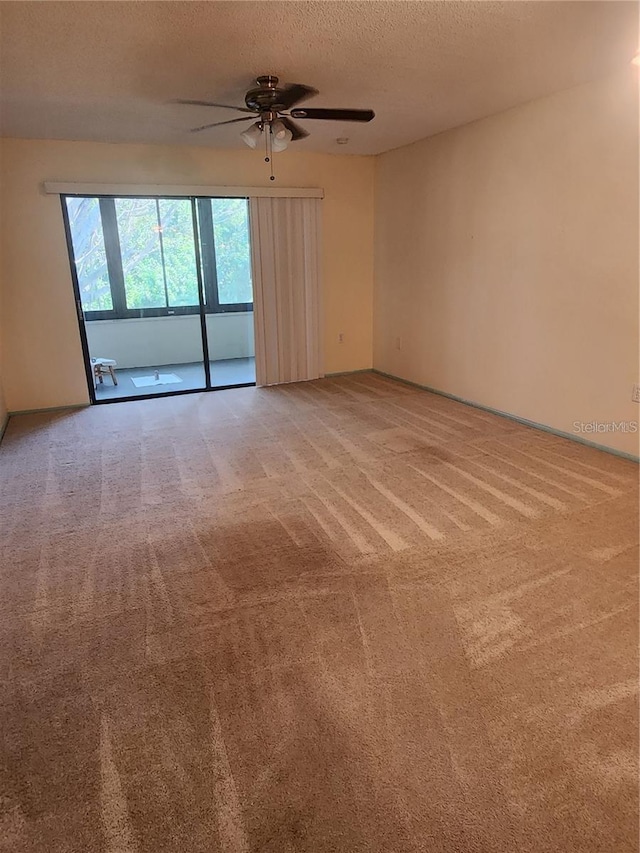 spare room with light colored carpet, ceiling fan, and a textured ceiling