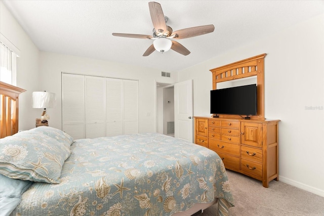 carpeted bedroom featuring a closet and ceiling fan