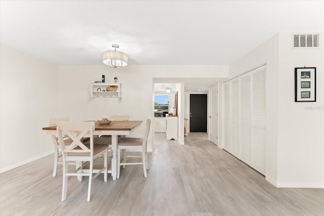 dining space with a notable chandelier and light wood-type flooring