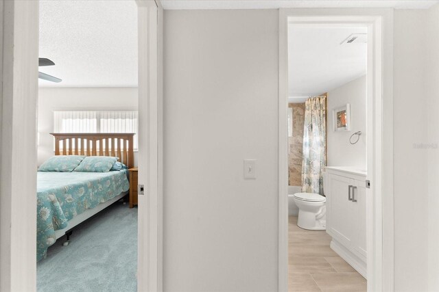 carpeted bedroom featuring ensuite bathroom and ceiling fan