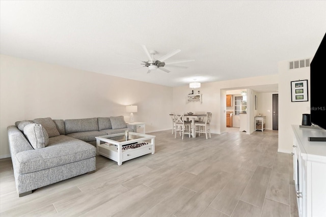 living room featuring light hardwood / wood-style flooring and ceiling fan