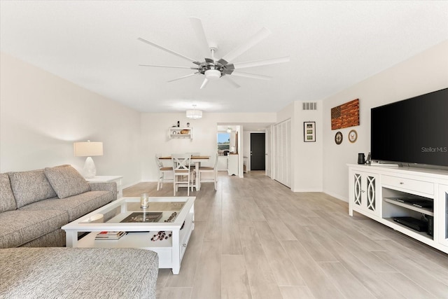 living room featuring ceiling fan and light wood-type flooring