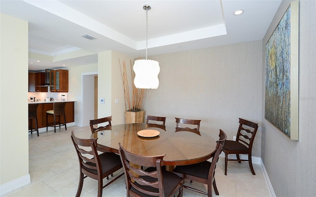 tiled dining area featuring a raised ceiling and an inviting chandelier