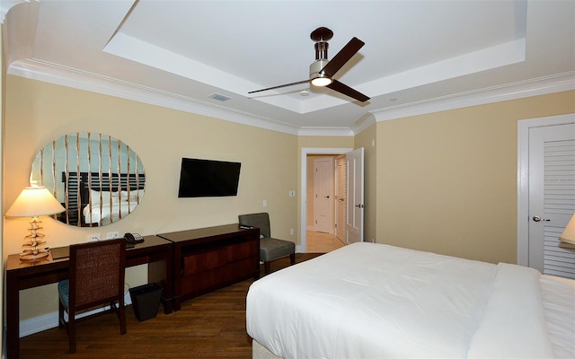 bedroom featuring a raised ceiling, crown molding, dark hardwood / wood-style flooring, and ceiling fan