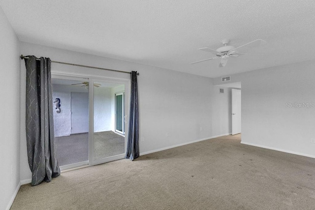 empty room with carpet flooring, ceiling fan, and a textured ceiling