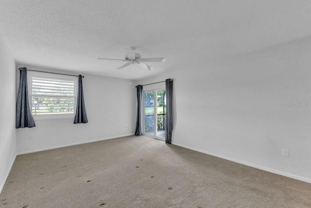 carpeted spare room with ceiling fan and a textured ceiling