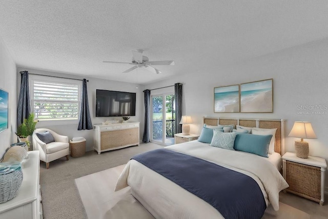 carpeted bedroom with ceiling fan and a textured ceiling