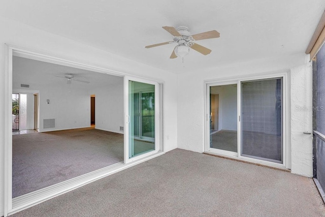 unfurnished sunroom featuring ceiling fan