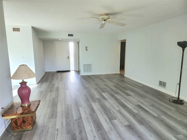 interior space with ceiling fan, light hardwood / wood-style floors, and a textured ceiling