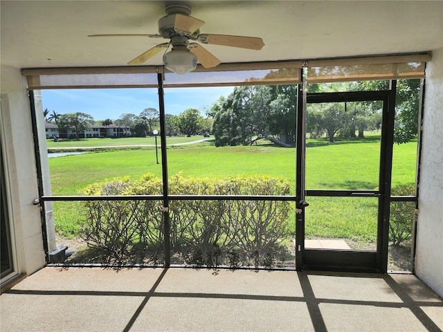 unfurnished sunroom featuring ceiling fan