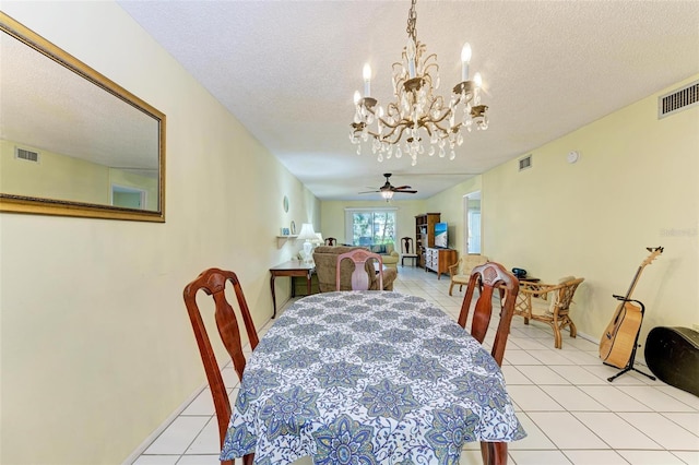 tiled dining room with a textured ceiling and ceiling fan with notable chandelier