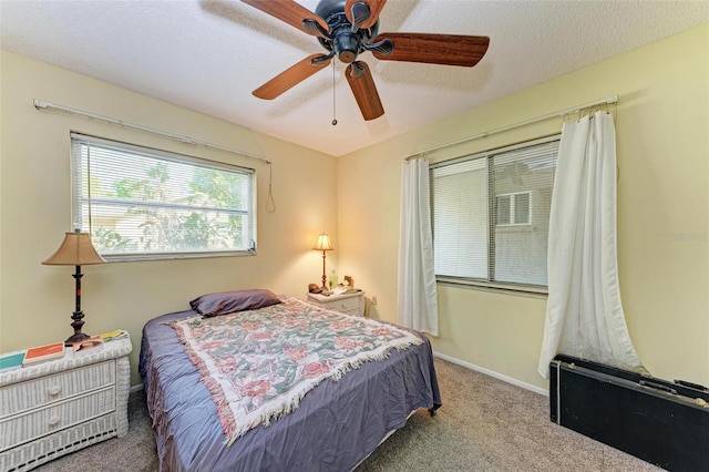 bedroom featuring light carpet, a textured ceiling, and ceiling fan