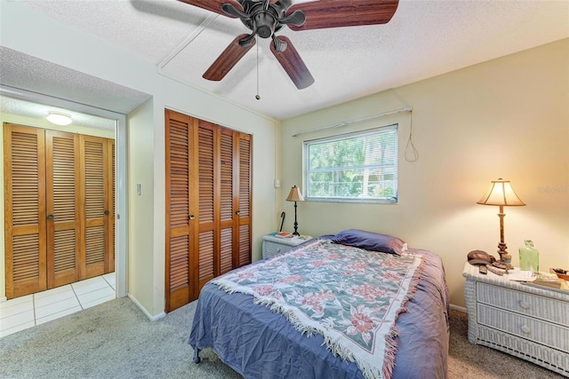 bedroom featuring light carpet, a textured ceiling, and ceiling fan