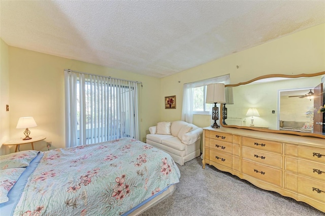 bedroom with light colored carpet, access to outside, and a textured ceiling