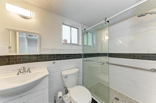 bathroom with toilet, oversized vanity, a textured ceiling, tasteful backsplash, and tile walls