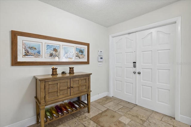 tiled foyer featuring a textured ceiling