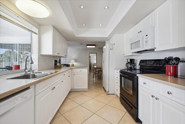 kitchen with white appliances, white cabinets, a tray ceiling, and sink