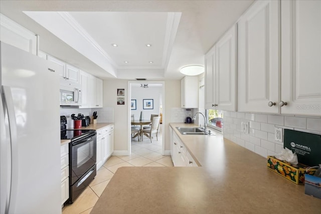 kitchen with white appliances, white cabinets, backsplash, and a tray ceiling