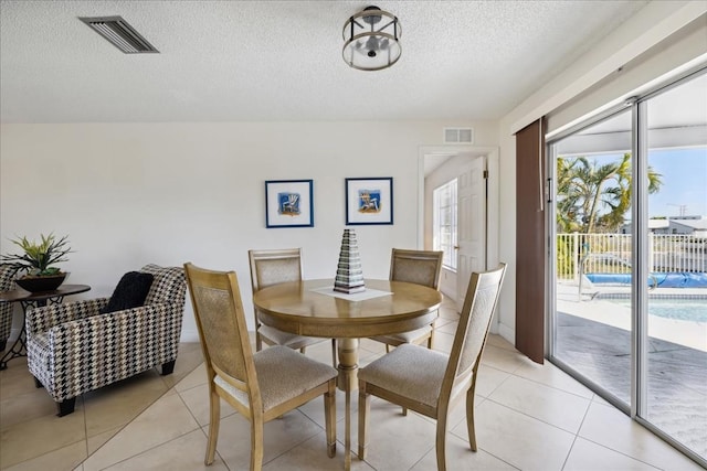 tiled dining space featuring a textured ceiling