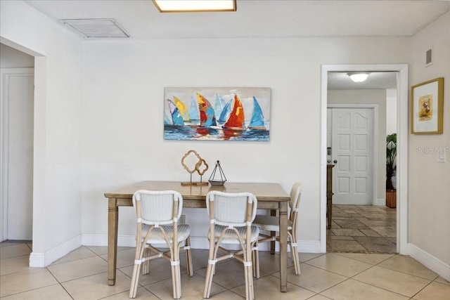 dining space featuring light tile floors