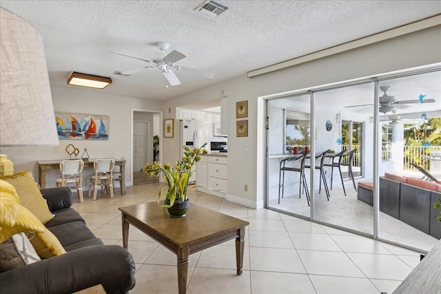 tiled living room with a textured ceiling and ceiling fan