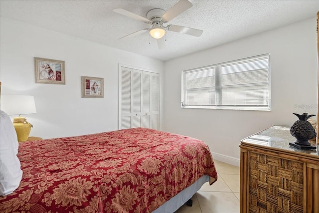 tiled bedroom with a textured ceiling, a closet, and ceiling fan