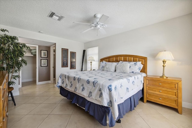 tiled bedroom featuring a textured ceiling and ceiling fan